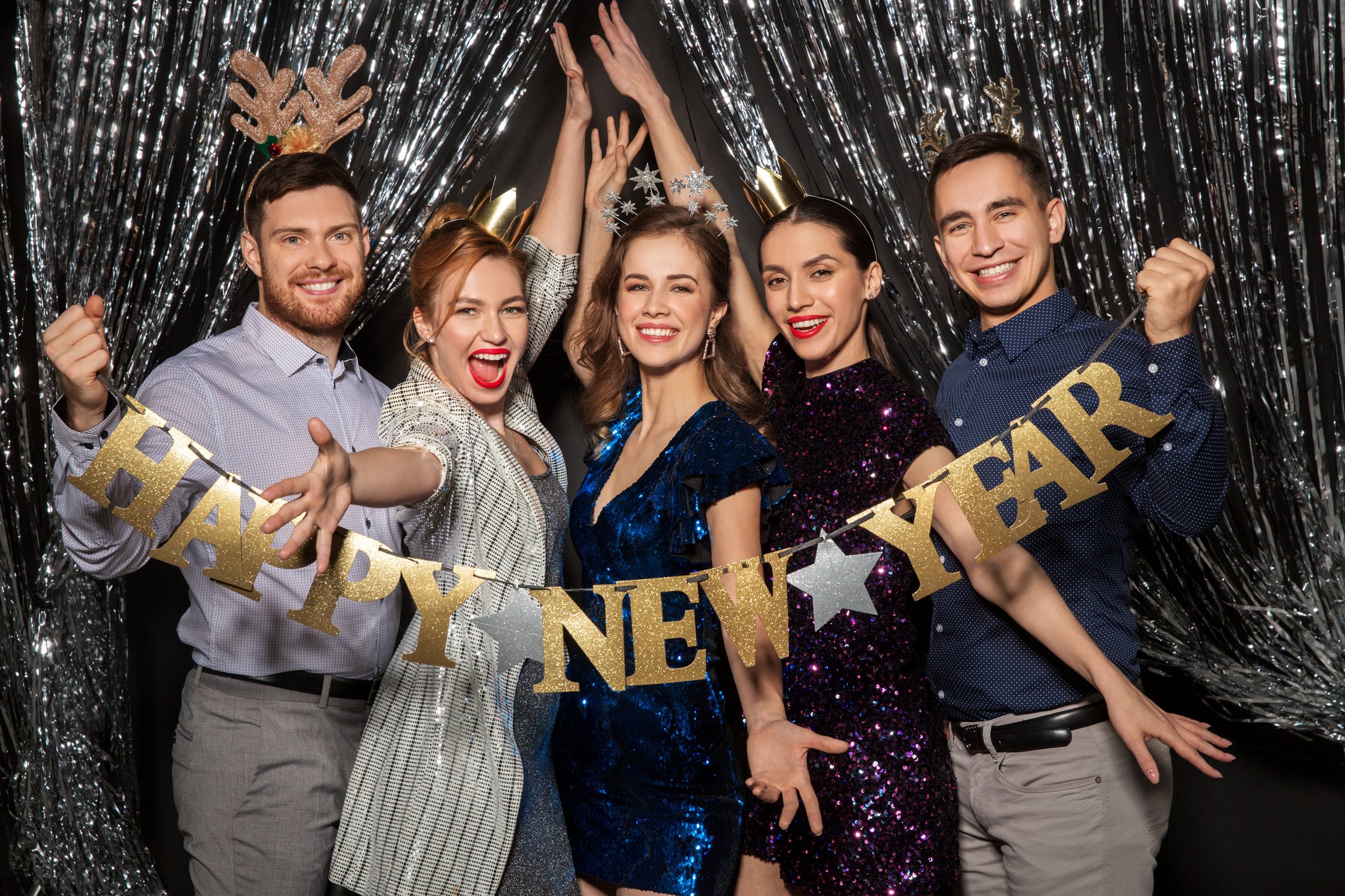 Happy Friends Posing with New Year Banner